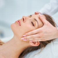 Young nice woman having face massage in spa. High quality photo